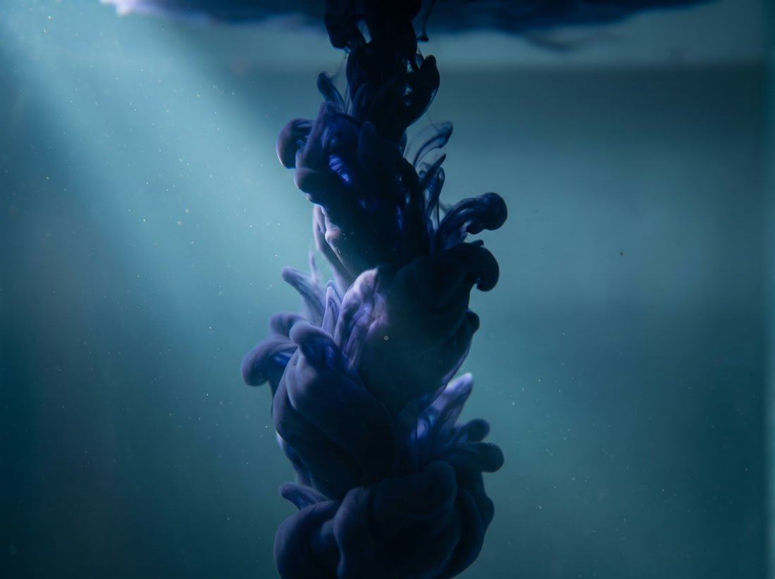 Tinte im Wasser, die sich zu einer klaren senkrechten Form ordnet